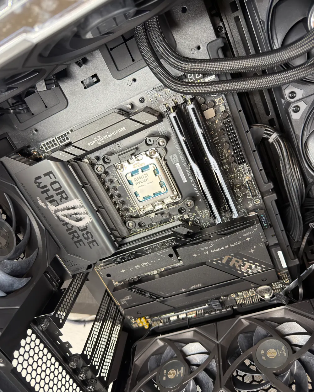 Inside an SCS build: an AMD Ryzen 7 9800X3D on an ASUS ROG Strix X870E-E motherboard, with white G.Skill memory, braided cables and liquid cooling lines.